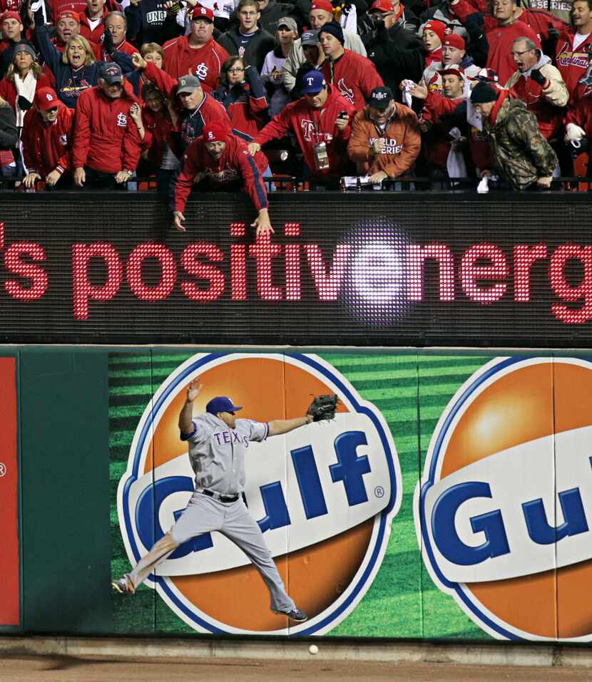 St. Louis Cardinals fans reach as Texas Rangers right fielder Nelson Cruz can't come up with...