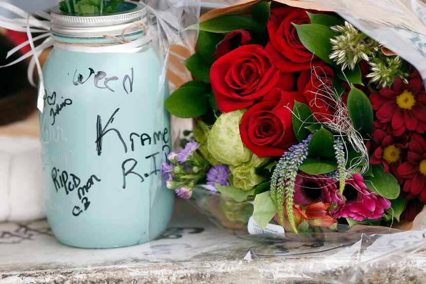 Flowers and messages are left at a makeshift memorial outside the Triple S convenience store...