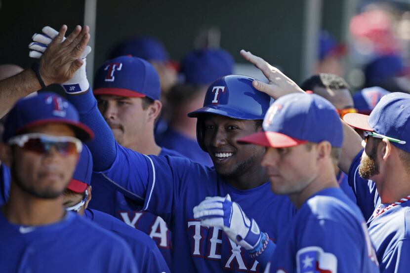 Texas Rangers' Jurickson Profar is congratulated in the dugout after hitting a solo home run...