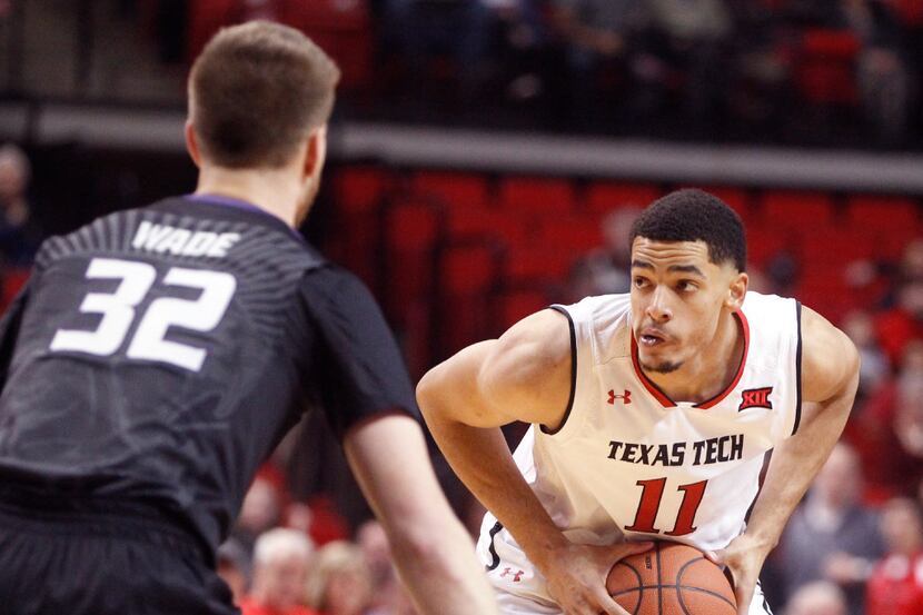 Texas Tech forward Zach Smith (11) looks for an open teammate defended by Kansas State...