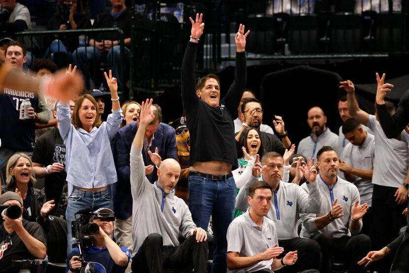 Dallas Mavericks owner Mark Cuban , center, reacts during the first half of an NBA...