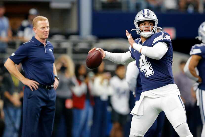 FILE - Cowboys coach Jason Garrett (left) watches quarterback Dak Prescott (4) warm up...