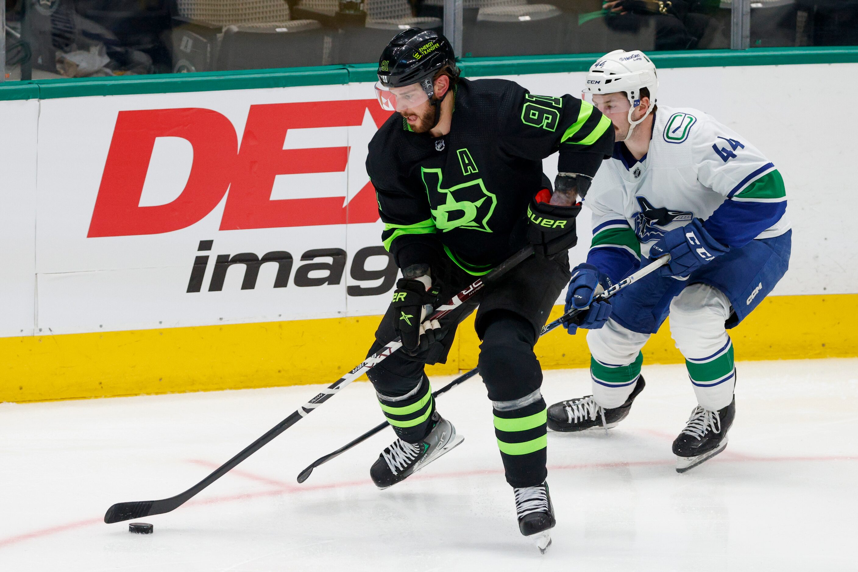 Dallas Stars center Tyler Seguin (91) handles the puck ahead of Vancouver Canucks defenseman...