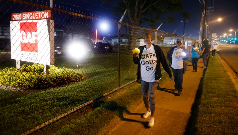 A group of neighbors march to nearby GAF, a residential and commercial roofing plant on...