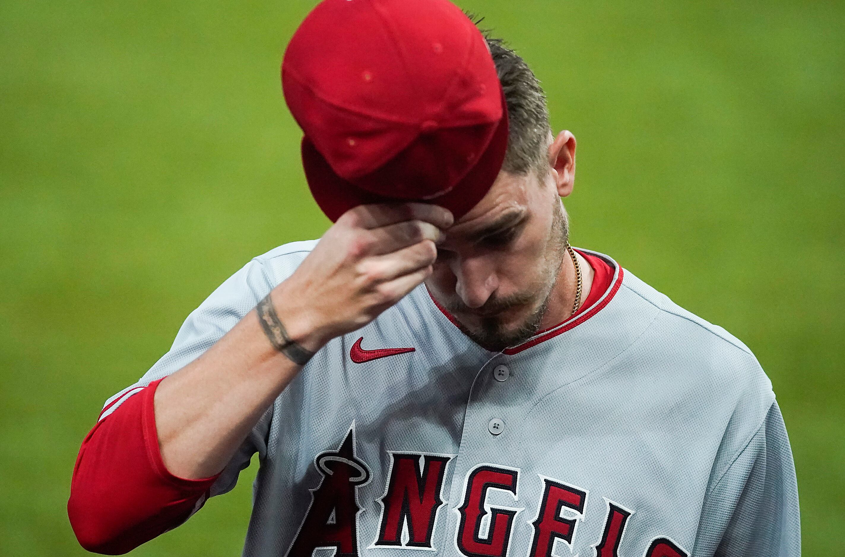 Los Angeles Angels starting pitcher Andrew Heaney heads to the dugout after being pulled...
