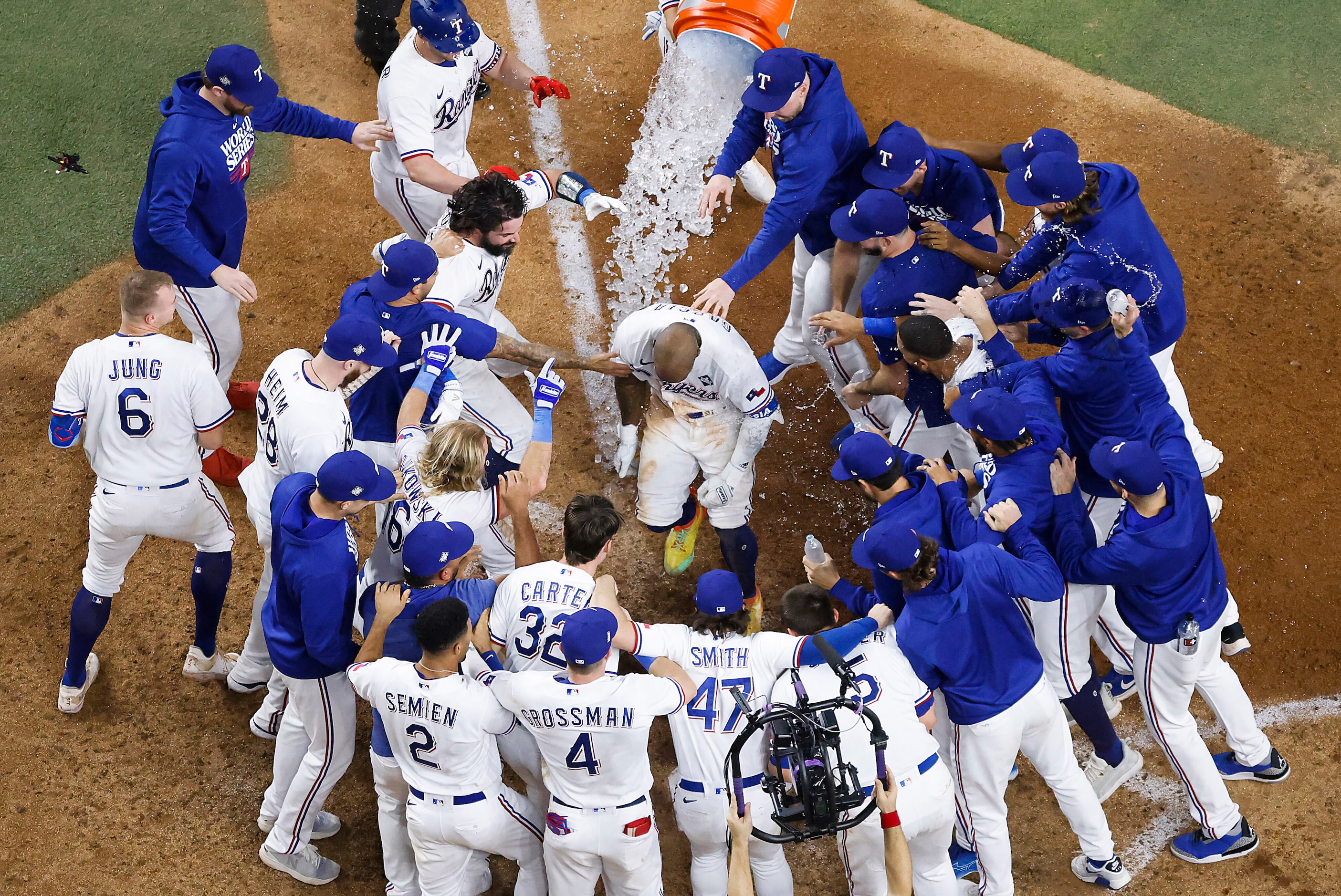 Texas Rangers right fielder Adolis Garcia is mobbed at home plate after hitting a walk-off...