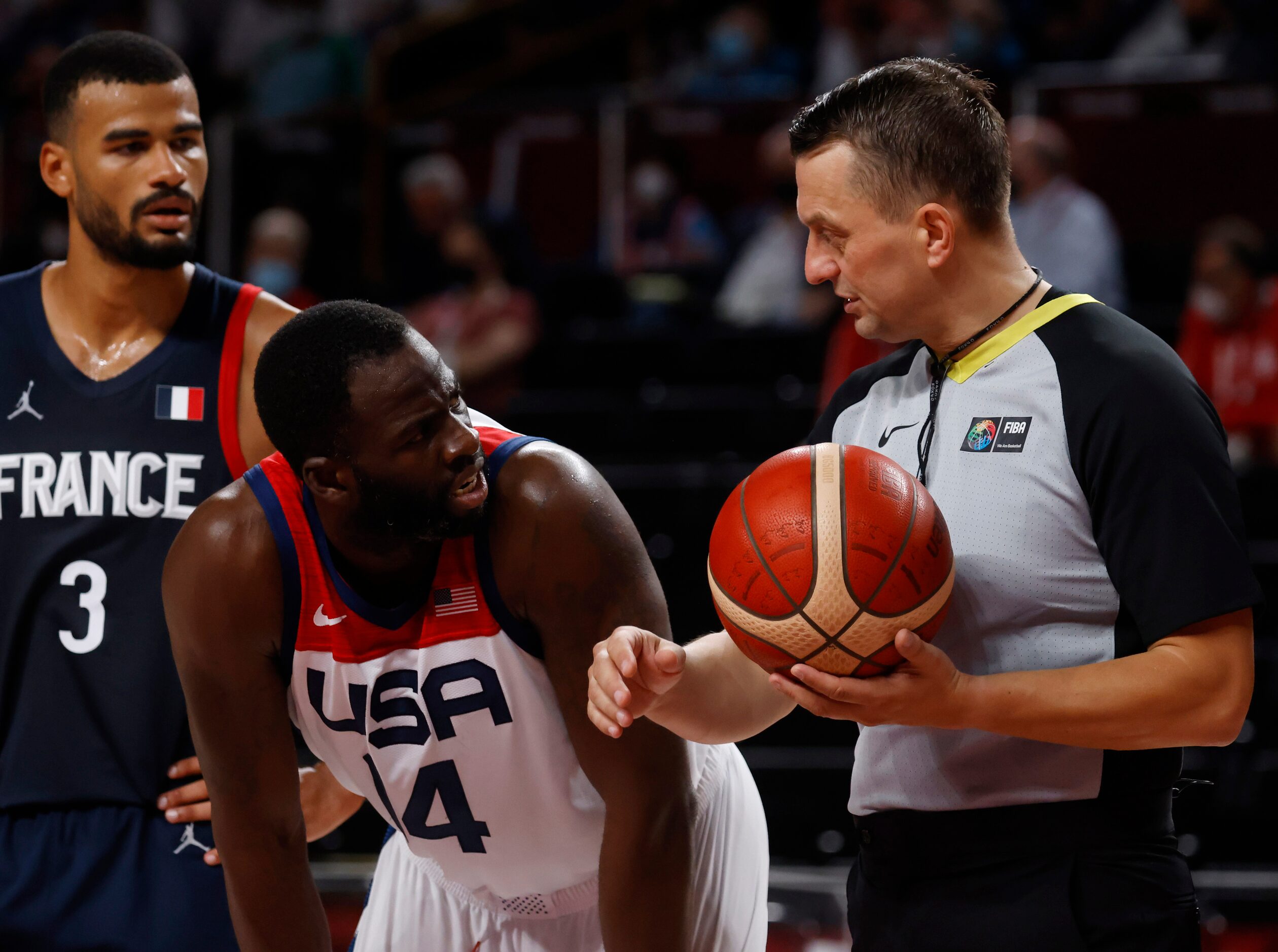 USA’s Draymond Green (14) questions a call from a referee in a game against France during...