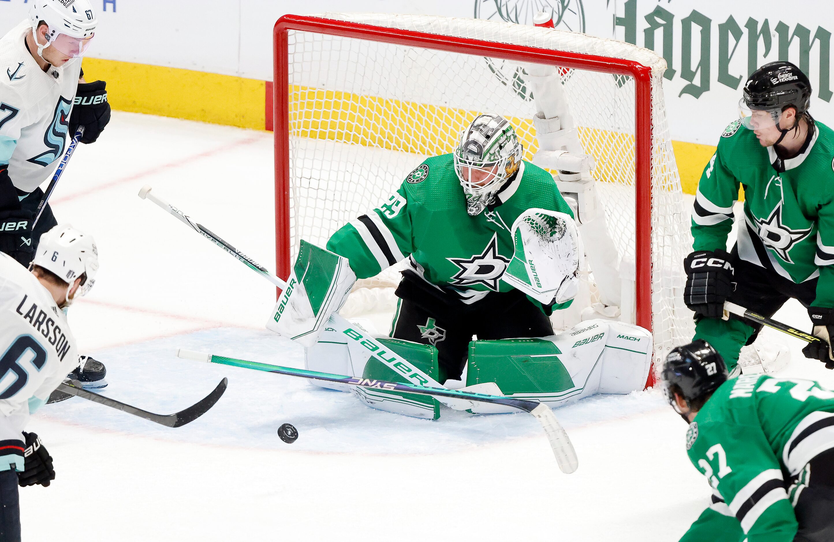 Dallas Stars goaltender Jake Oettinger (29) stops a shot by Seattle Kraken defenseman Adam...