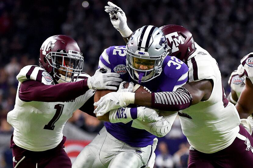 Kansas State running back Justin Silmon (32) is tackled by Texas A&M's Nick Harvey (1) and...