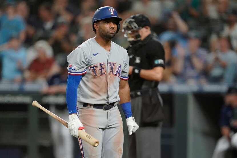 Texas Rangers' Ezequiel Duran walks back to the dugout after striking out swinging with two...