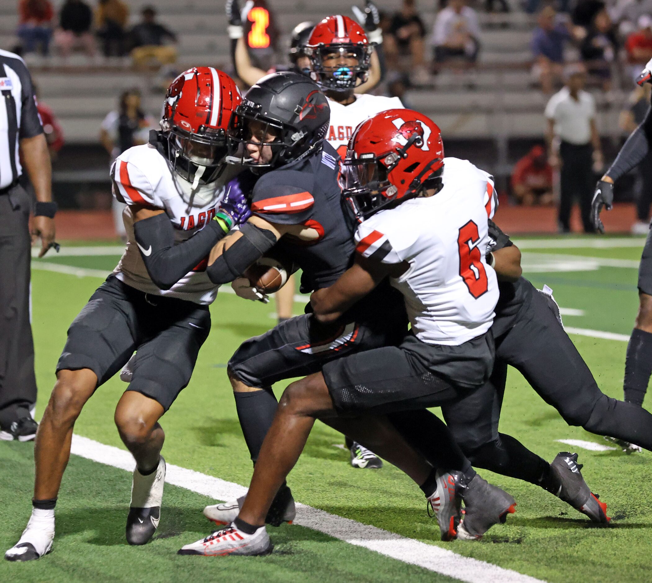 Rockwall Heath QB Jack Davenport (17) forces his way through a group of Mesquite Horn...