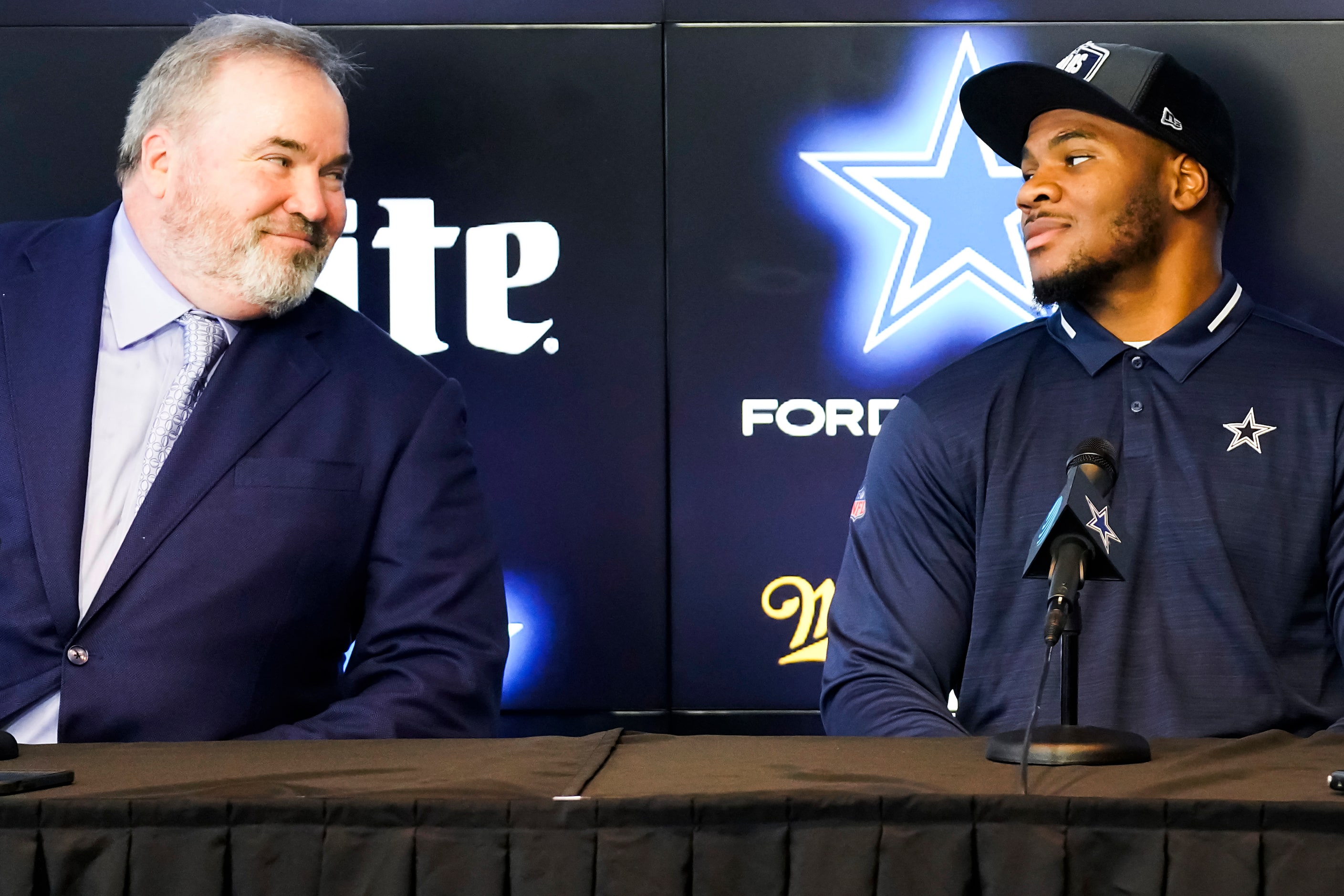 Dallas Cowboys first-round draft pick Micah Parsons (right) looks to head coach Mike...