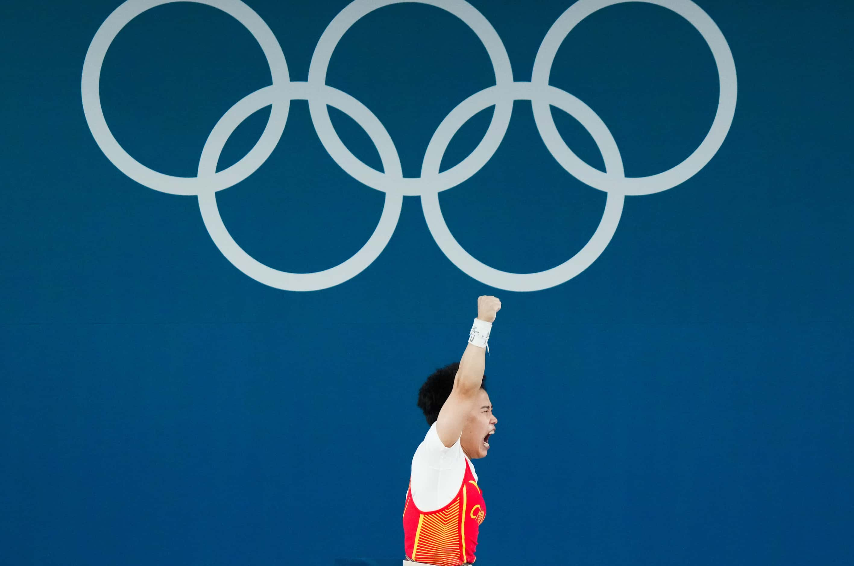 Hou Zhihui of China reacts after lifting 117kg, a new Olympic record, in the in the clean...