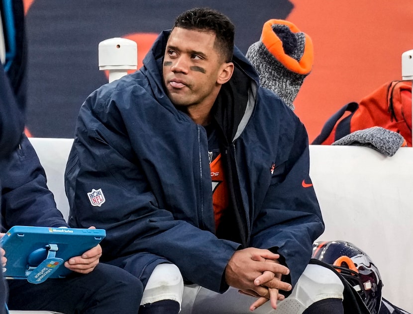 FILE - Denver Broncos quarterback Russell Wilson sits on the bench during the second half of...