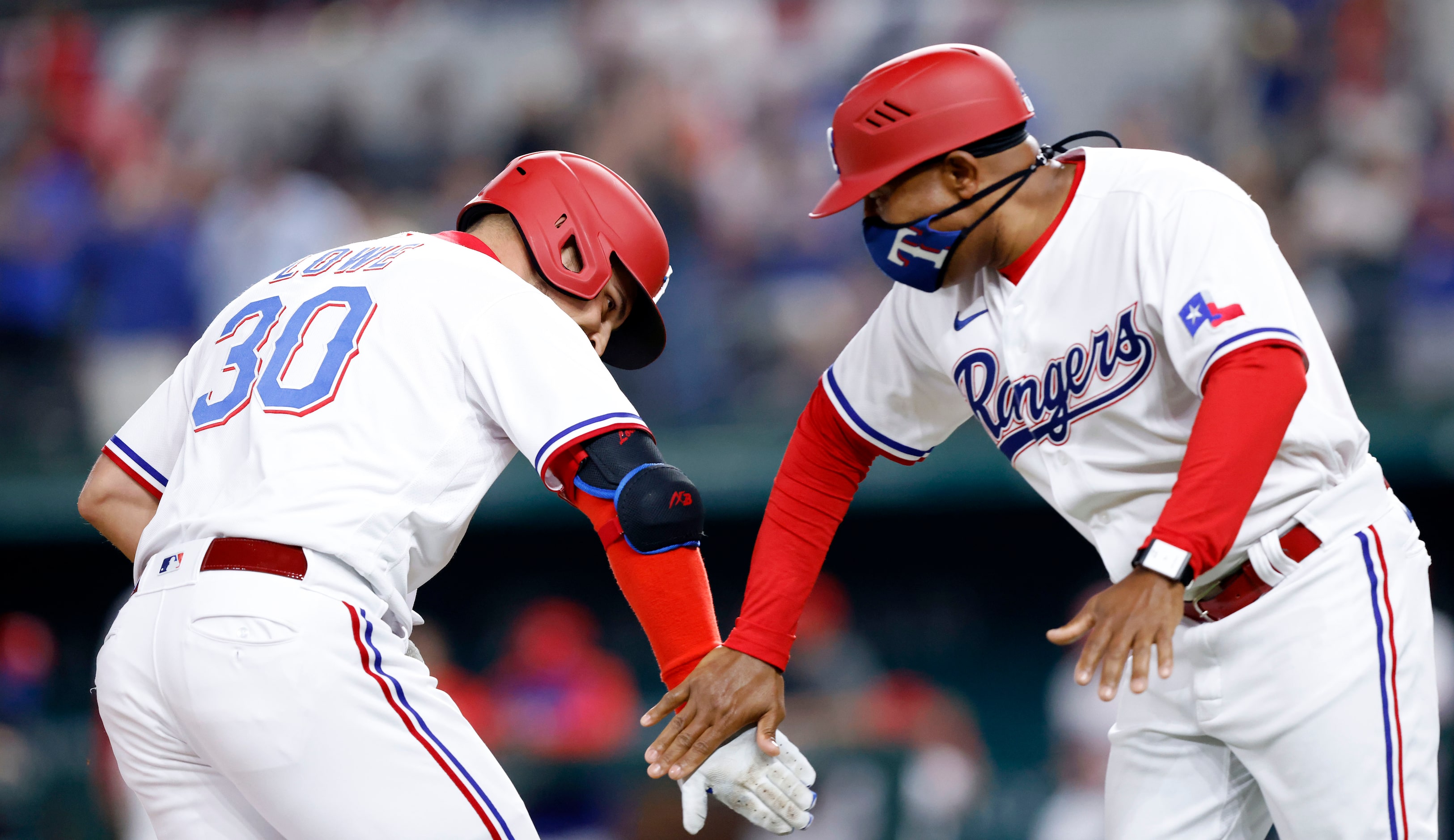 Texas Rangers batter Nate Lowe (30) is congratulated on his two-run homer by third base...