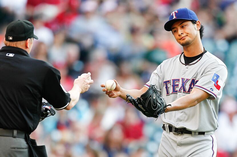 HOUSTON - MAY 11:  Yu Darvish #11 of the Texas Rangers hands the ball to home plate umpire...