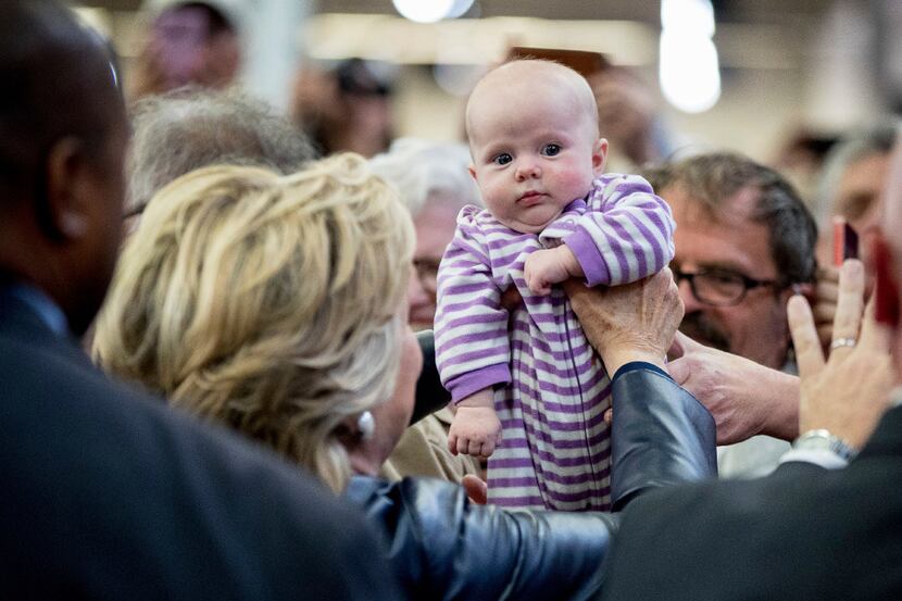 Democratic presidential candidate Hillary Clinton picks up a baby as she greets members of...
