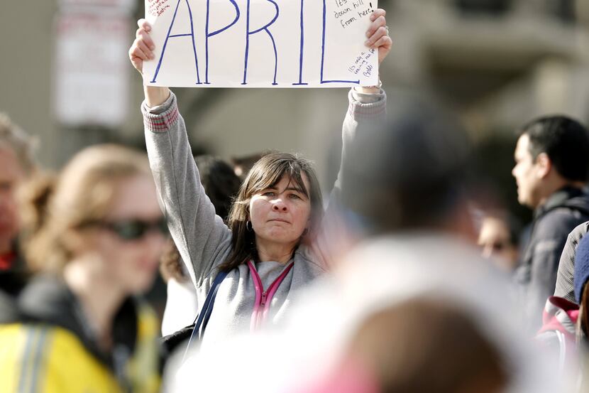 Justine Franco of Montpelier, Vt., holds up a sign near Copley Square in Boston looking for...