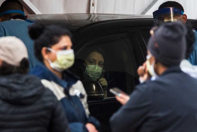 Nurses work at the drive-through coronavirus testing site at American Airlines Center in...