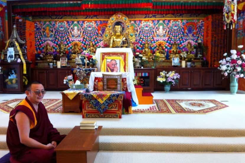 A monk sits before the altar in the shrine room of the Tibetan Mongolian Buddhist Cultural...