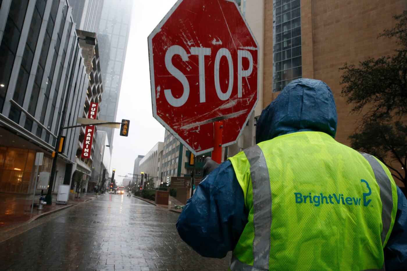 A construction worker stops traffic during a rainy week in downtown Dallas.