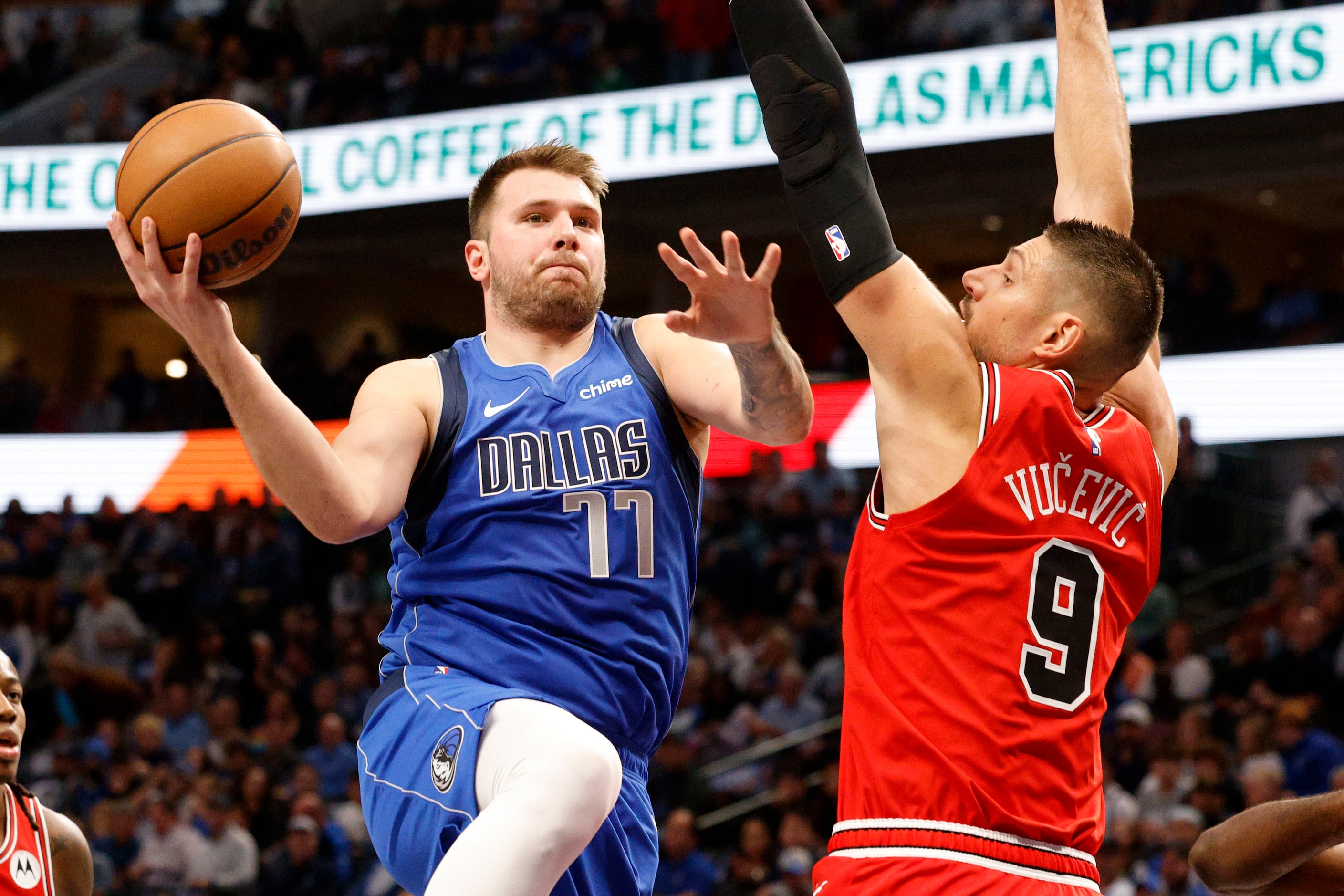 Dallas Mavericks guard Luka Doncic (77) shoots over Chicago Bulls center Nikola Vucevic (9)...