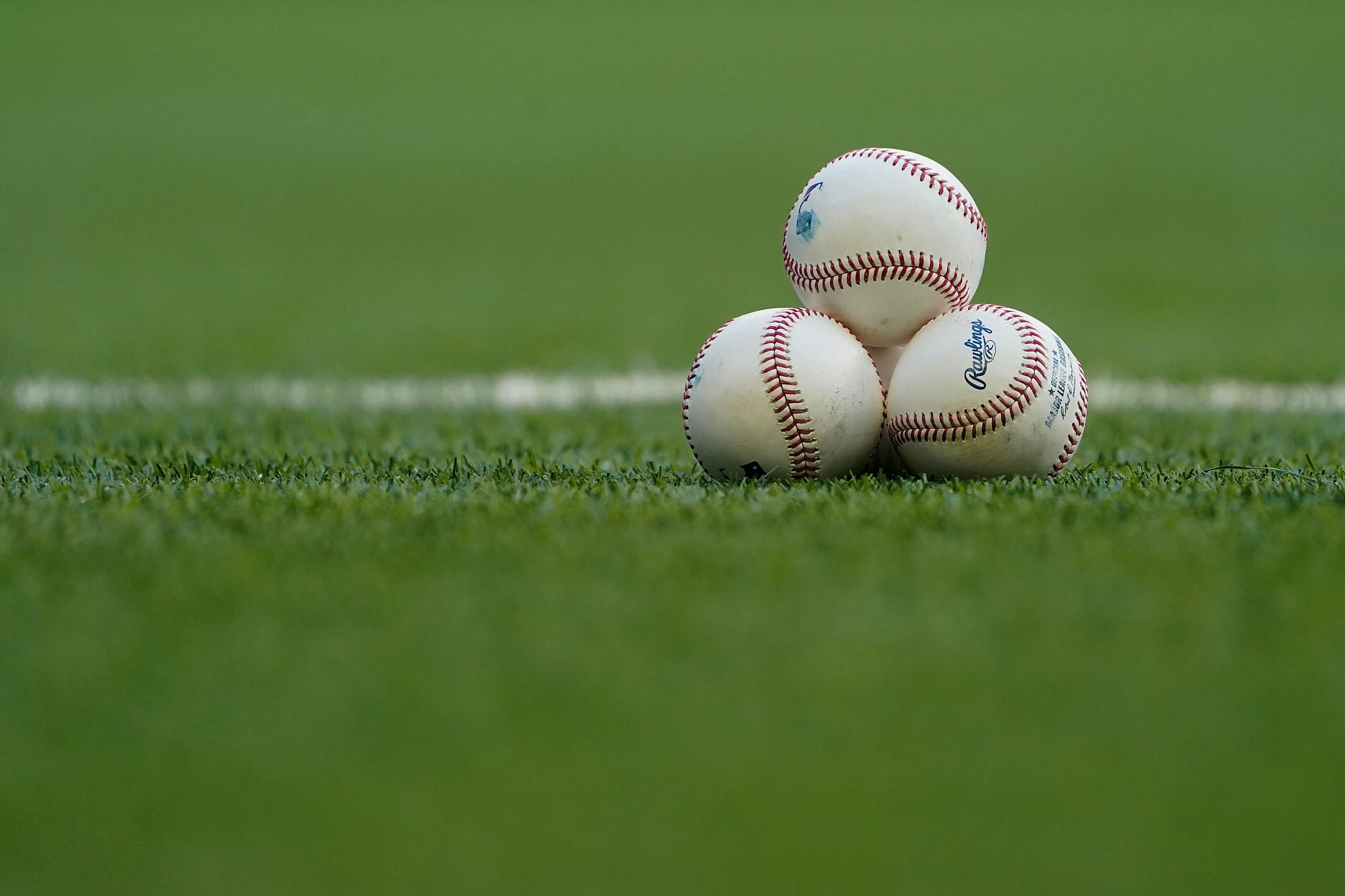 Balls rest on the field before the Texas Rangers face the San Diego Padres at Globe Life...