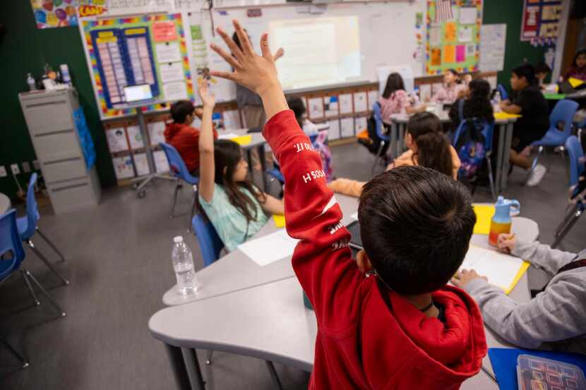 Students raise their hand in a classroom at the Bowie Fine Arts Academy in Grand Prairie on...
