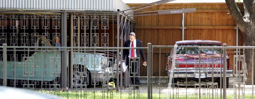 Agents examine several vehicles at John Wiley Price's home in 2011 during a search of his...