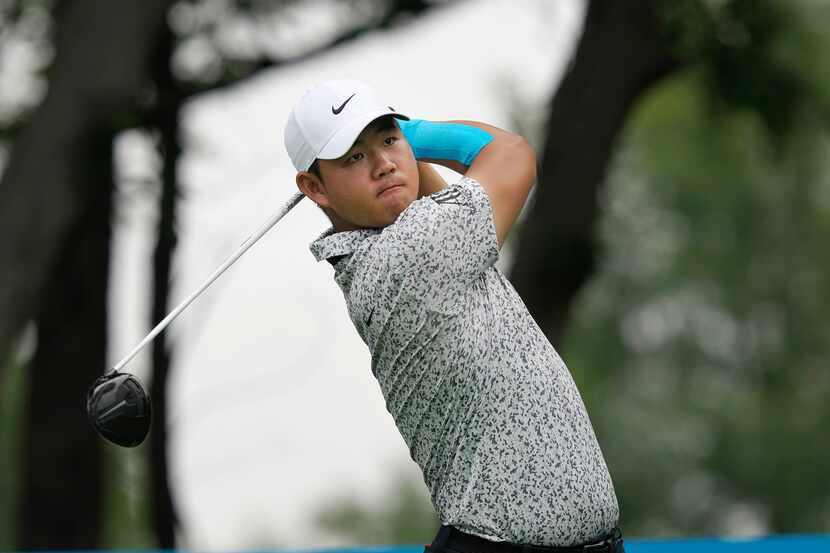 Tom Kim, of South Korea, watches his tee shot on the second hole during the first round of...