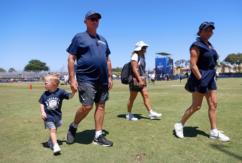 Dallas Cowboys defensive coordinator Mike Zimmer walks hand-in-hand with his grandson Bodie...