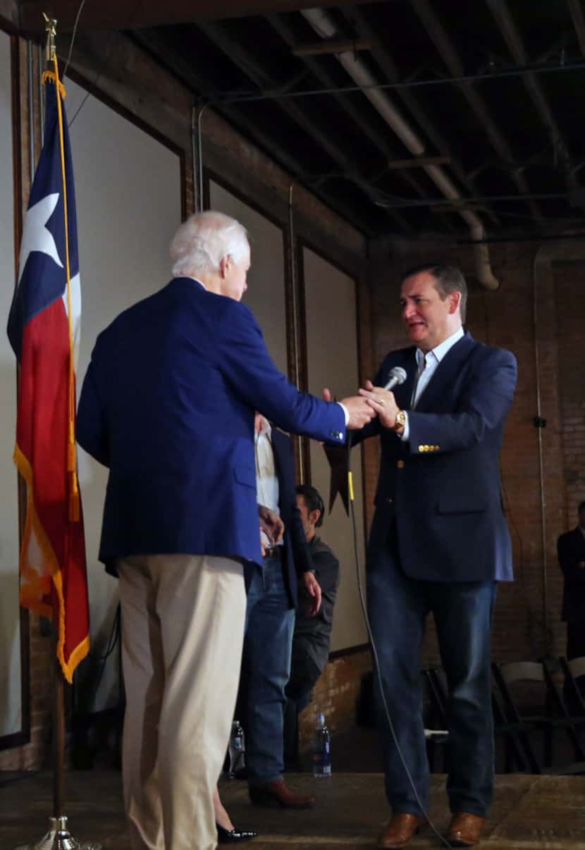Sen. Ted Cruz (right) takes the microphone from Sen. John Cornyn after Cornyn introduced...