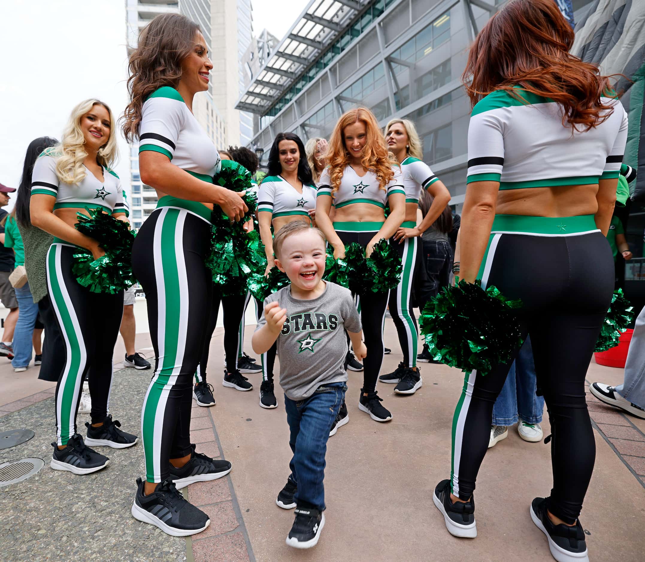 Teddy Wilder, 5, of Dallas, center, runs after greeting Dallas Stars Ice Girls before Game 1...