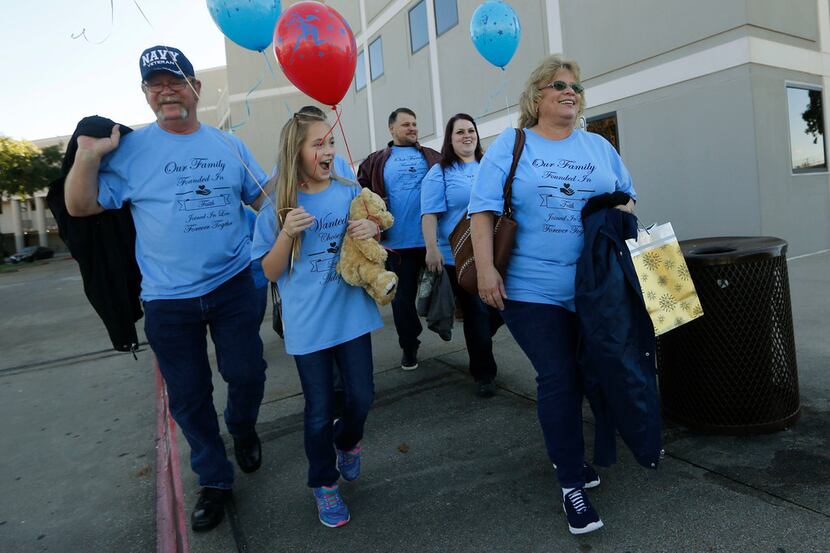 Dalyla Ludwig, 10, walks out of the courthouse with her new parents, Tim and DeAnne Ludwig,...
