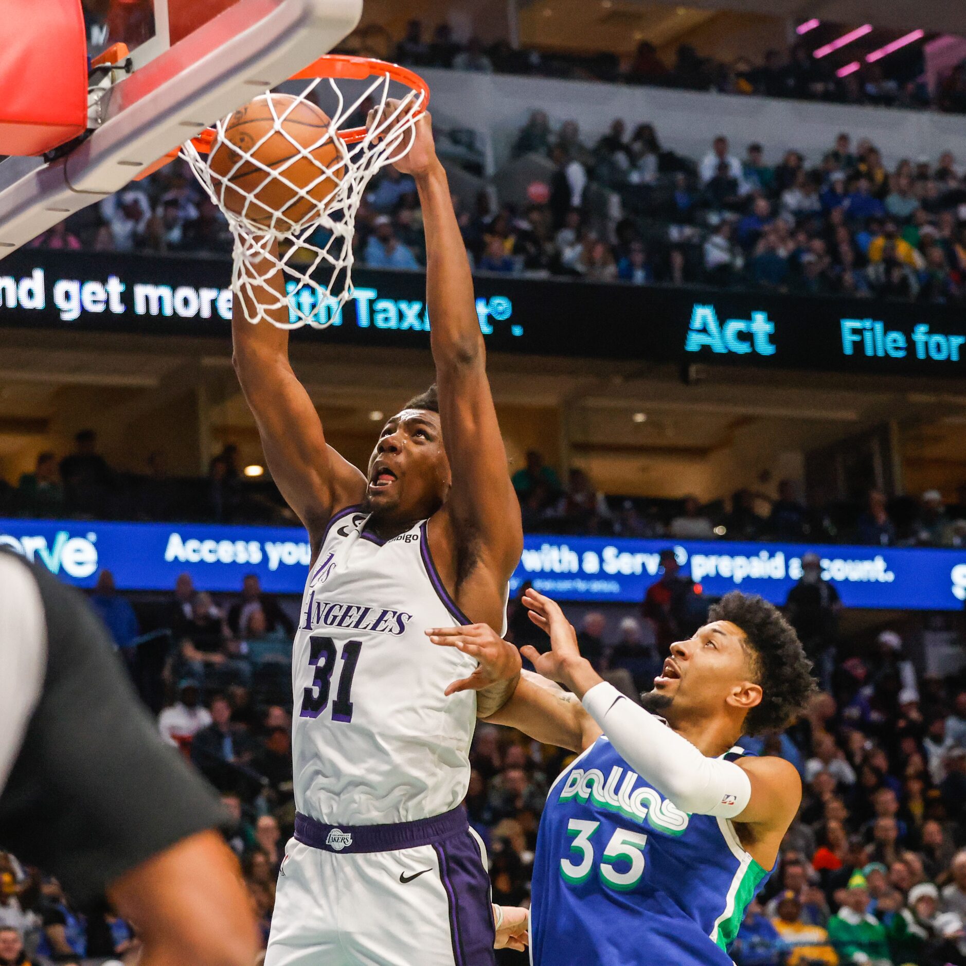 Los Angeles Lakers center Thomas Bryant (31) dunks the basketball next to Dallas Mavericks...