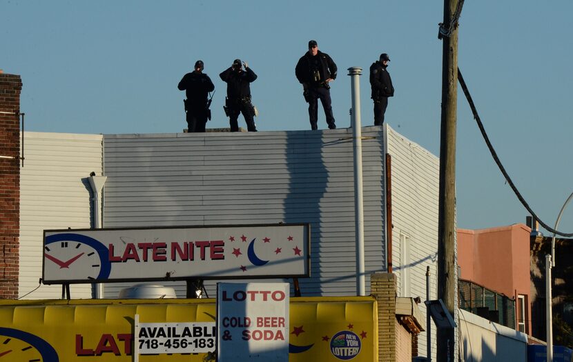 New York City police officers watch over the lines outside the wake for NYPD officer Rafael...