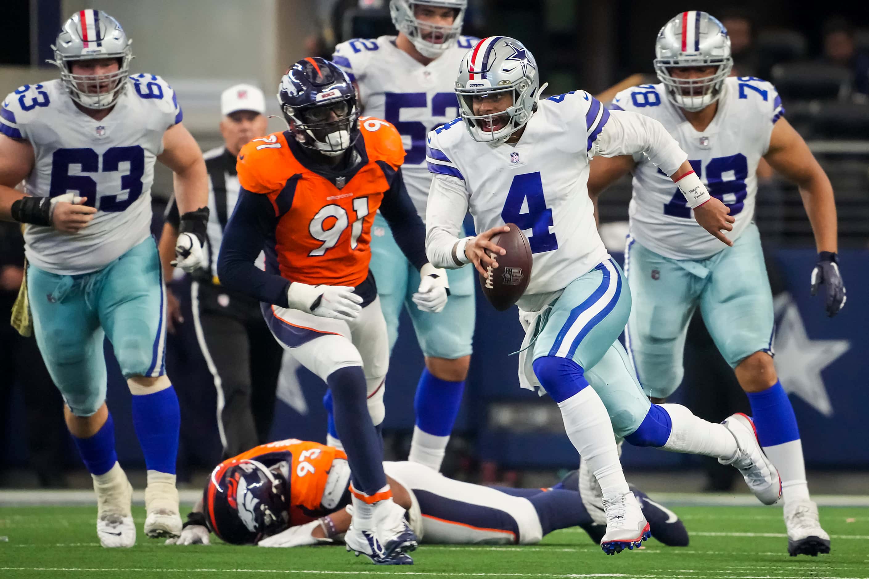 Dallas Cowboys quarterback Dak Prescott (4) scrambles for a first down past Denver Broncos...