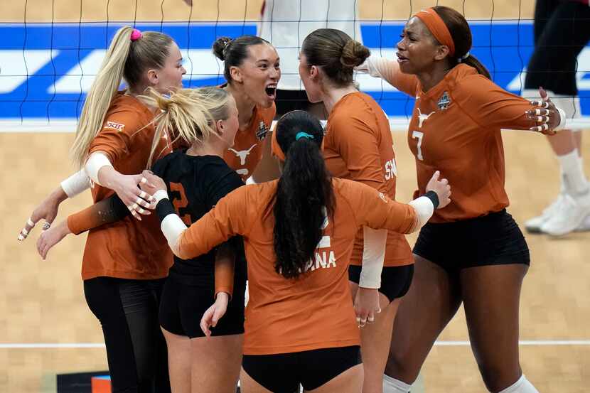 Texas players celebrate a point against Wisconsin during a semifinal match in the NCAA...