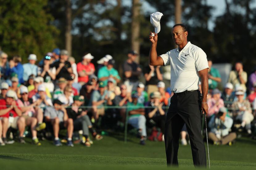 Tiger Woods tips his hat as he finishes on the 18th green in the second round of the Masters...
