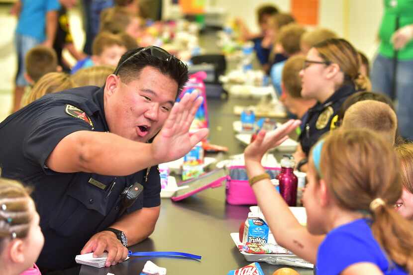 Hickory Creek police officer Mike Miller high fives a Corinth Elementary student during...