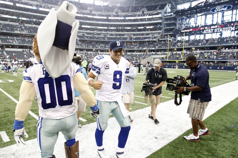 Cowboys quarterback Tony Romo was welcomed off the field by mascot Rowdy on Sunday after...