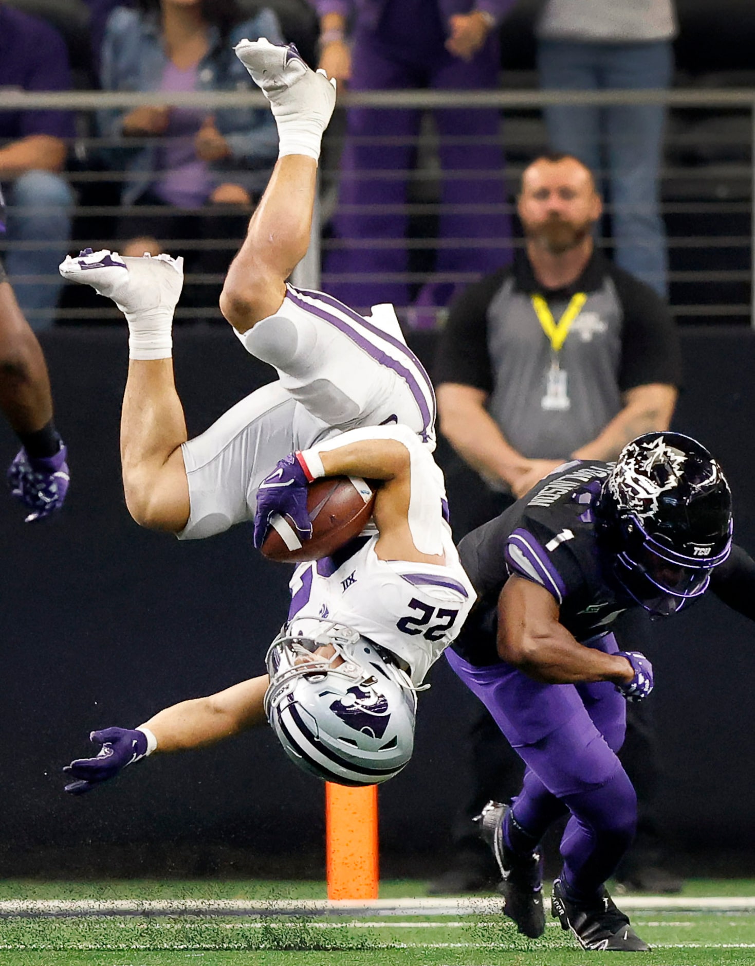 Kansas State Wildcats running back Deuce Vaughn (22) is flipped over after having his legs...