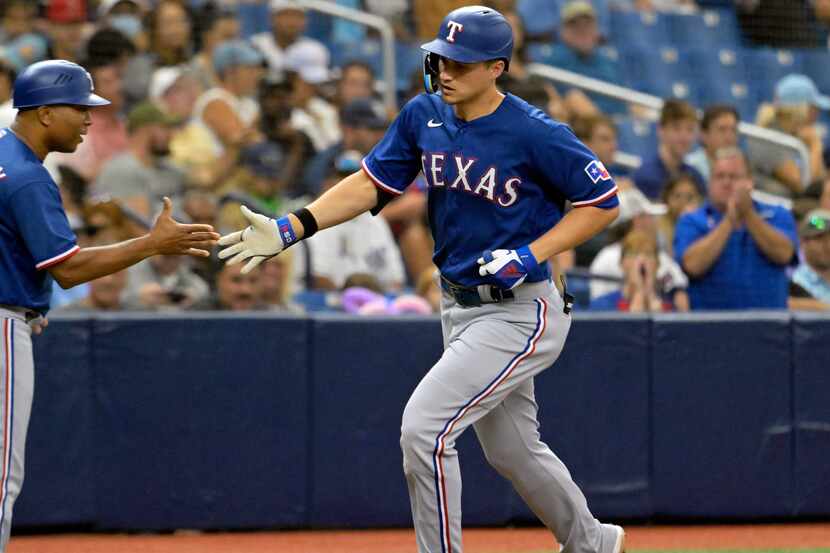 Texas Rangers third base coach Tony Beasley (27) congratulates Corey Seager after Seager's...