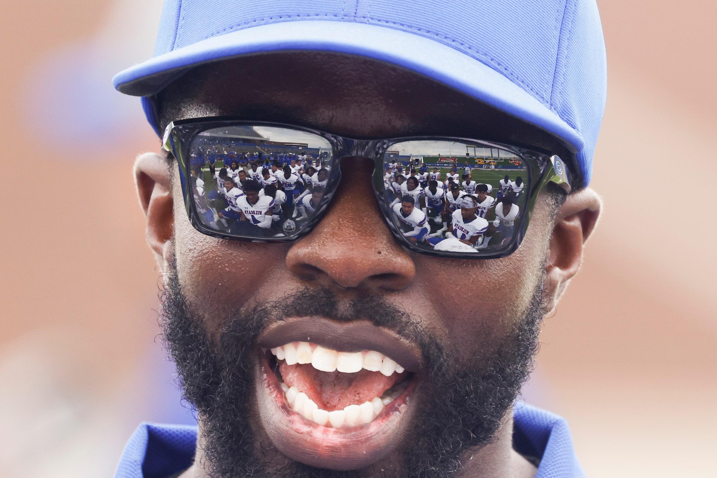 Temple High players are reflected on coach Dexter Knox’s sunglass as he speaks towards the...