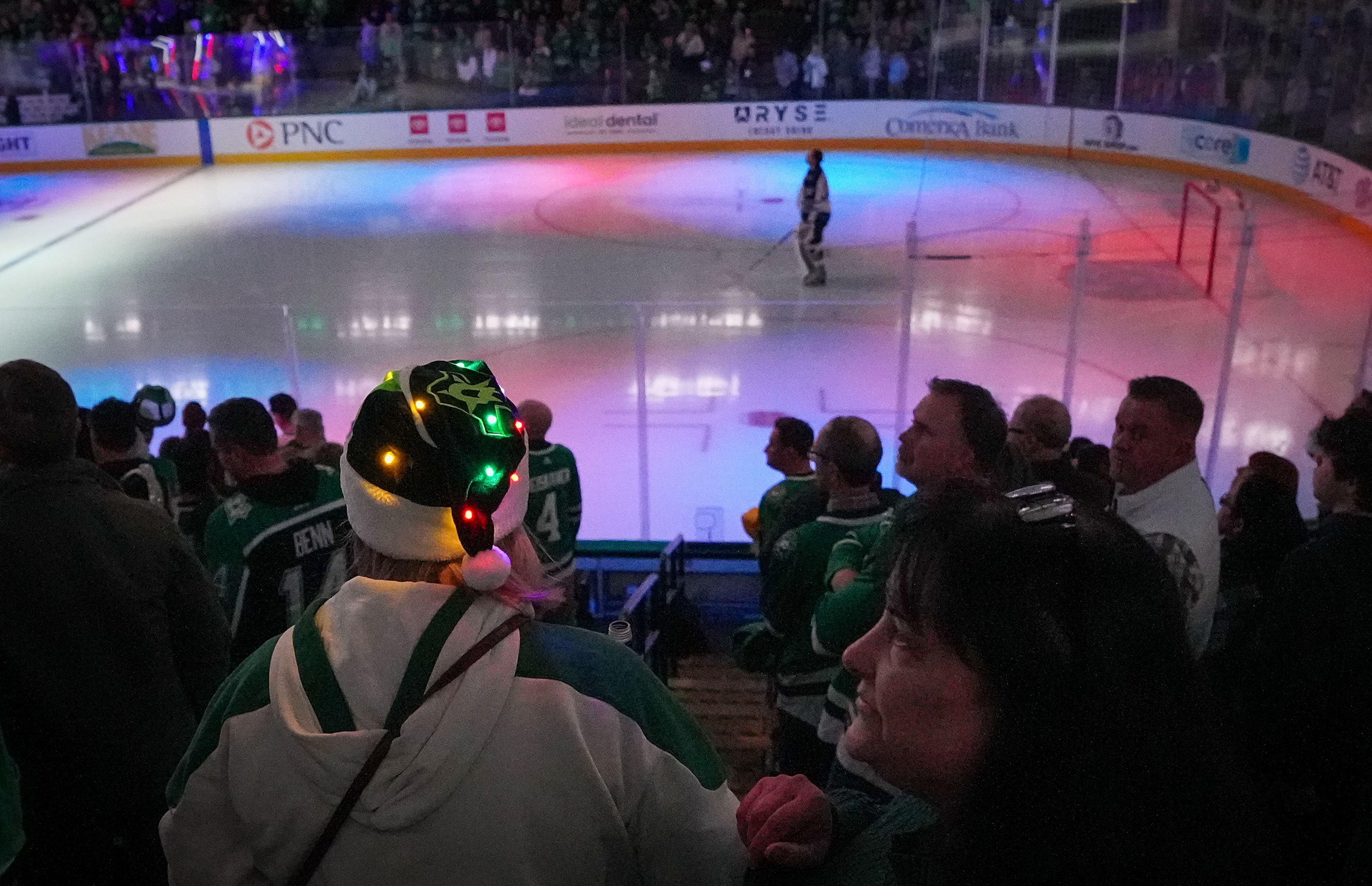 A Dallas Stars fan wears a festive lighted hat as they head to their seats for the first...