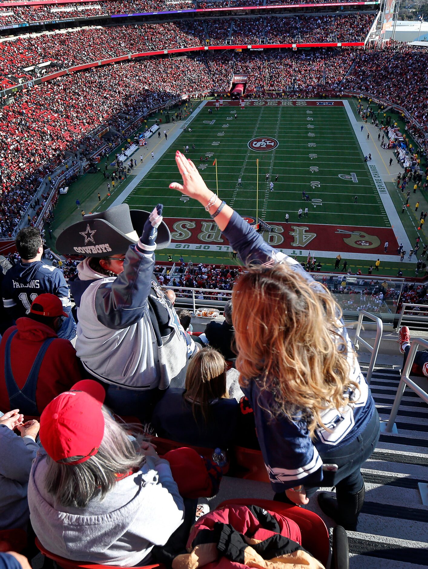 Dallas Cowboys fans high-five one another after they find themselves surrounded by San...