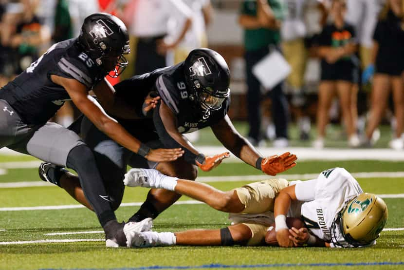 Mansfield Timberview defensive linemen Ontario Hewitt (25) and Dilan Battle (99) fall on...