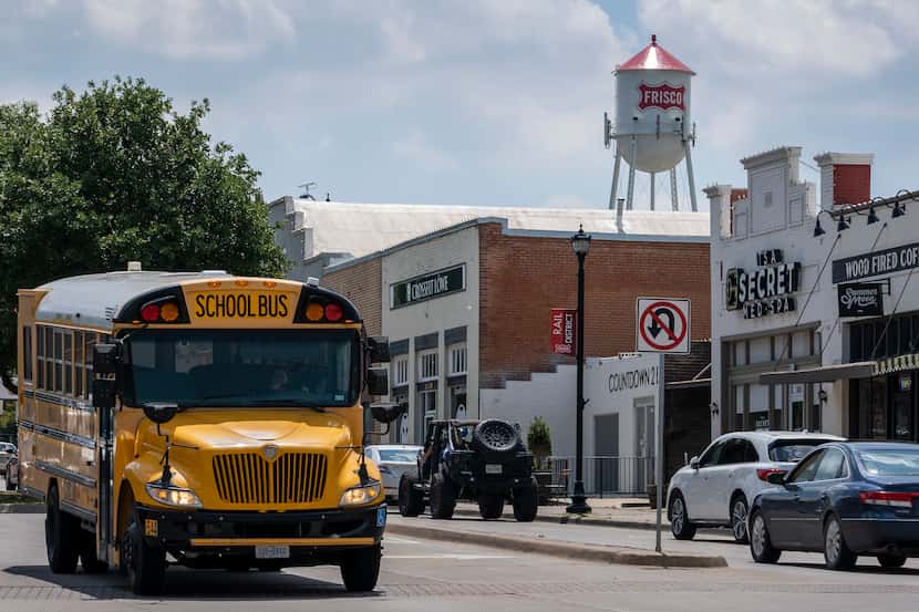 A Frisco ISD school bus passes along Main Street under the city's old iconic water tower....