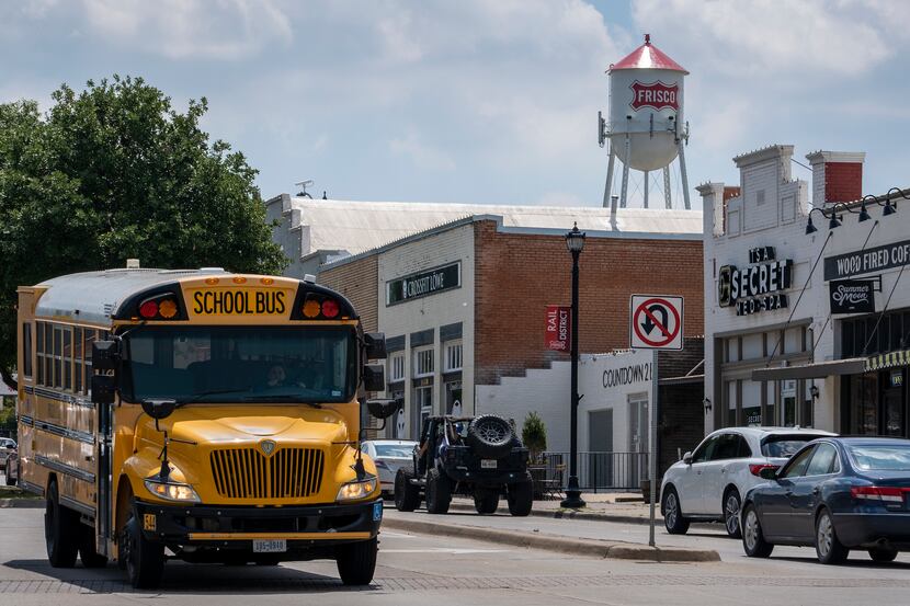 A Frisco ISD school bus passes along Main Street under the city's old iconic water tower....