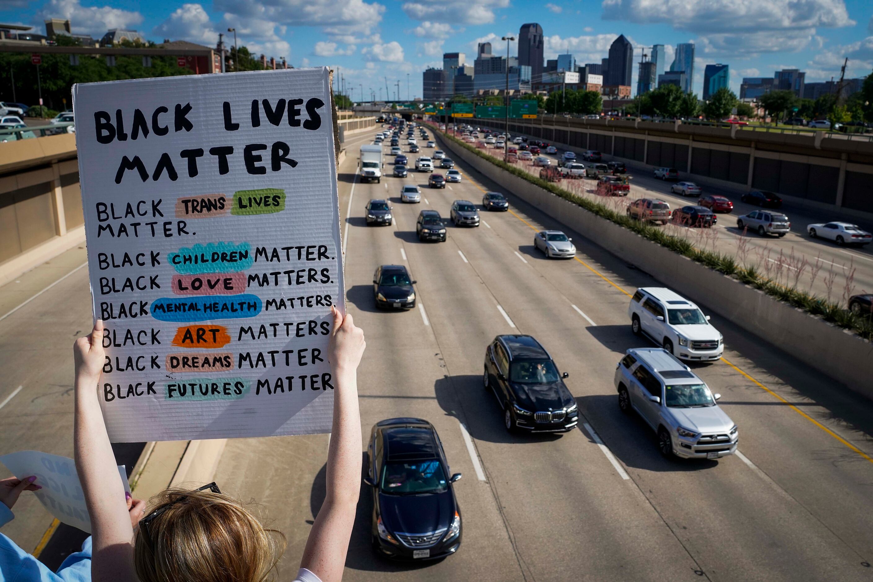 Protesters hold signs for rush hour motorists headed north out of downtown from the Lemmon...
